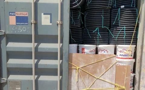 Lime buckets and conduit coils in a container for Douala