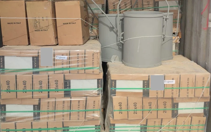 Palettes de carreaux et seaux de treuil disposés dans le conteneur pour Libreville